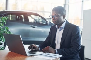 Office worker in Car Showroom at a computer